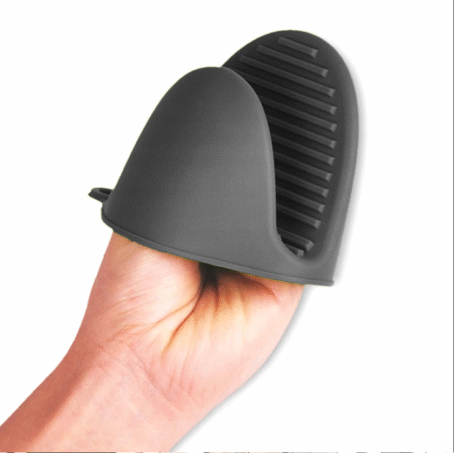 A black silicone oven mitt placed on a hand, with visible anti-slip grooves on the gripping side.