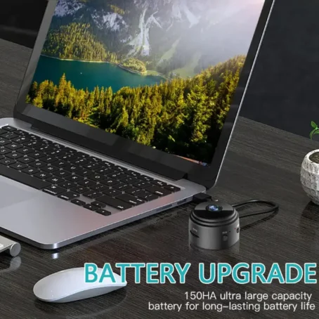 A laptop sits on a desk next to a wireless camera or mini speaker with a 150HA ultra large capacity battery, highlighting long-lasting battery performance and extended device usage on a single charge.