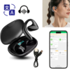Black wireless earphones with ear hooks, charging case with LED display, USB cable, a mobile app on a smartphone screen, and translation/audio icons. A woman shows the earphone worn on her ear.