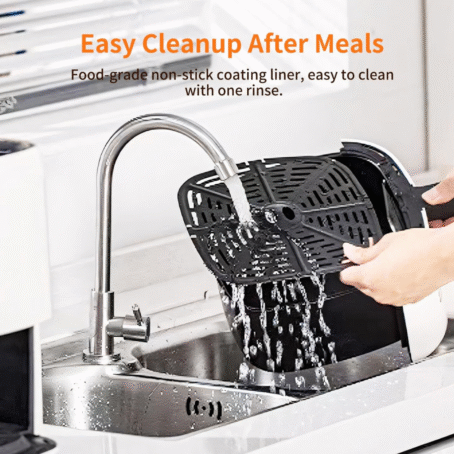 Person rinsing the non-stick air fryer basket under running water in a modern kitchen sink.